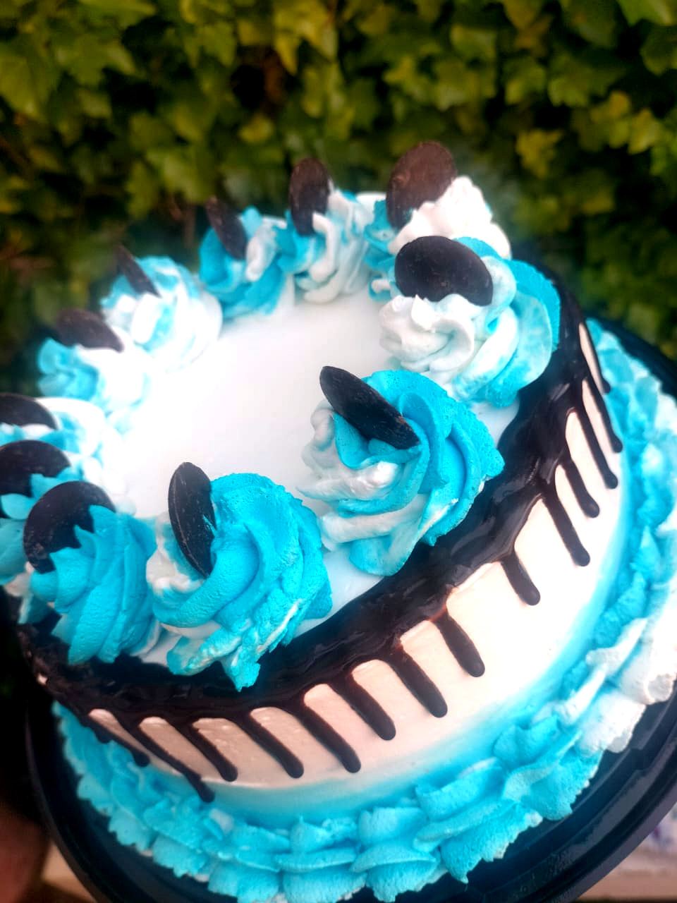 Torta decorada con crema azul, chocolate y galletas
