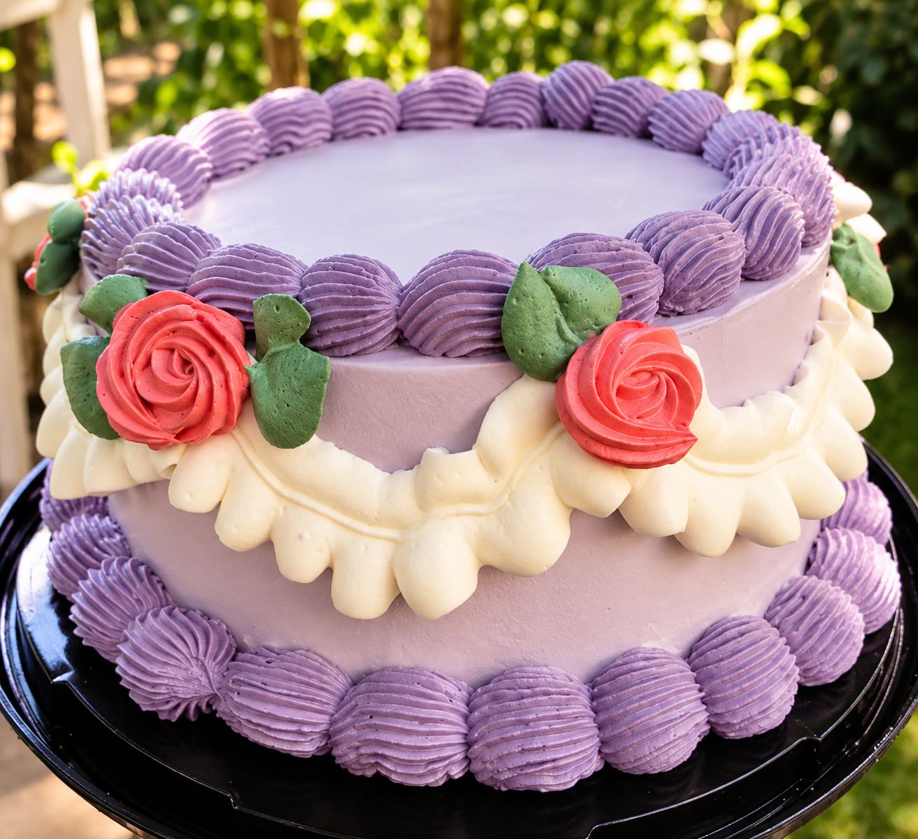 Torta lila decorada con rosas de crema y bordes ondulados
